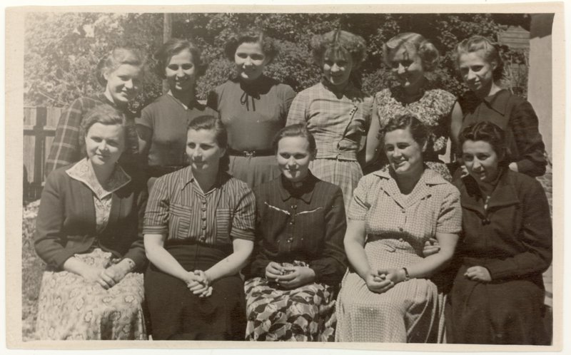 Sėdi bibliotekos darbuotojos (iš kairės): V. Paškauskienė, P. Kalpokienė, V. Petrauskaitė,  vedėja K. Dičkienė ir V. Kučinskaitė. Stovi – praktikantės iš Vilniaus kultūros mokyklos. 1956 m.