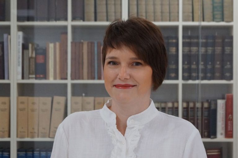 A woman standing next to books