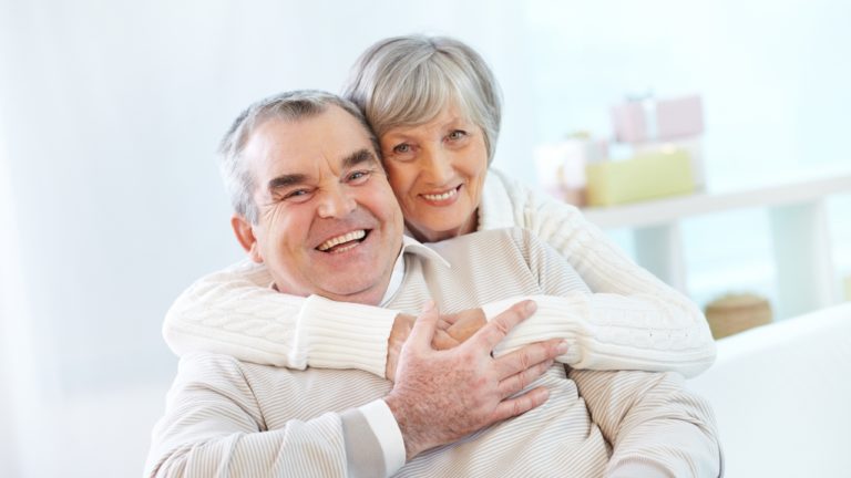 Vyresnio amžiaus vyras ir moteris šypsosi