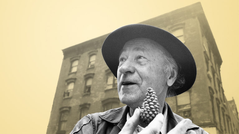 Jonas Mekas laiko kankorėžį didelio namo fone