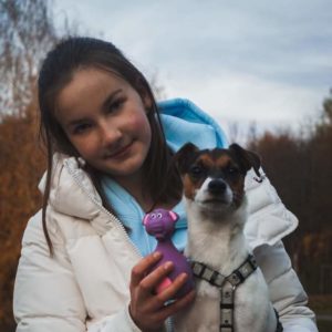 Mergaitė laiko šuniuką ir jo žaislą