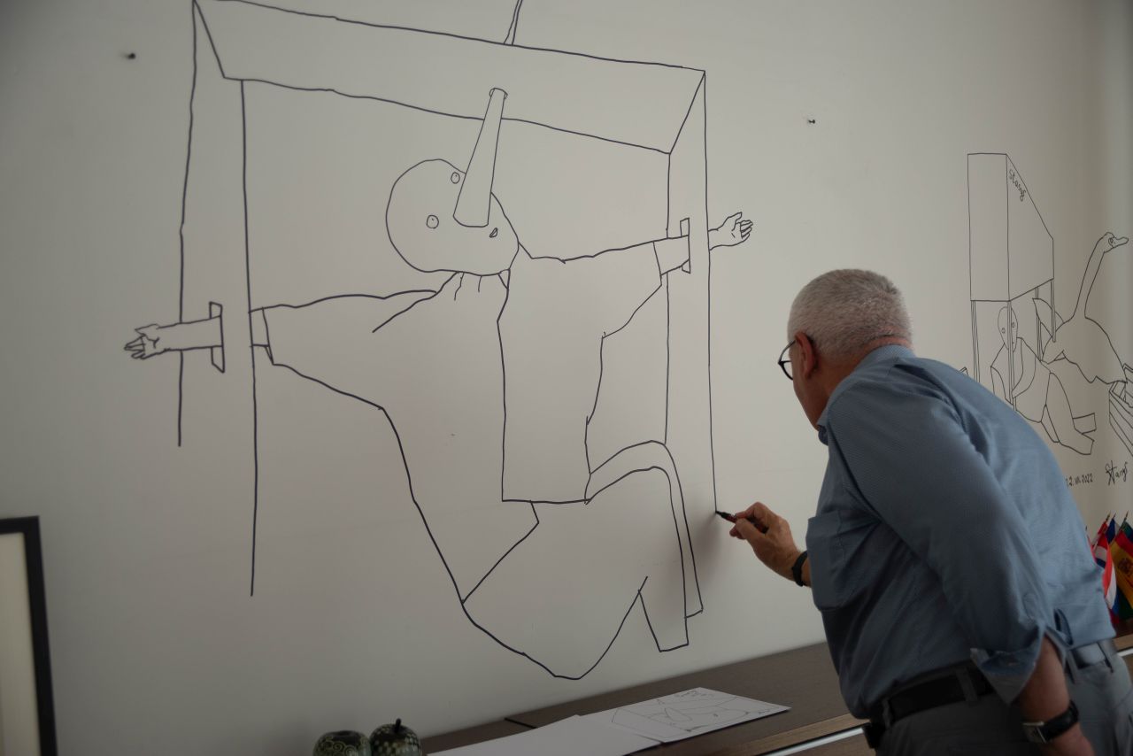 Vyras flomasteriu piešia piešinį ant sienos
