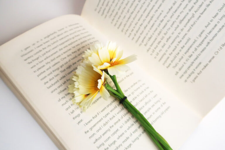 Gėlių ryšuliukas ant atverstos knygos puslapių