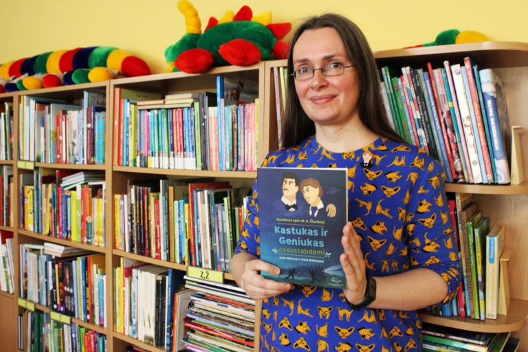 Moteris laiko knygą rankose bibliotekos lentynų fone