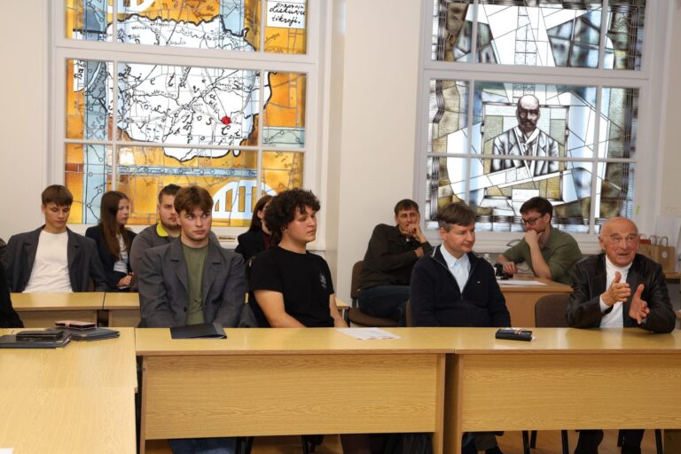 Penktoji mokinių filosofijos konferencija „Filosofija ir Dialogas“ Jaunuoliai ir filosofai sėdi už stalų salės fone