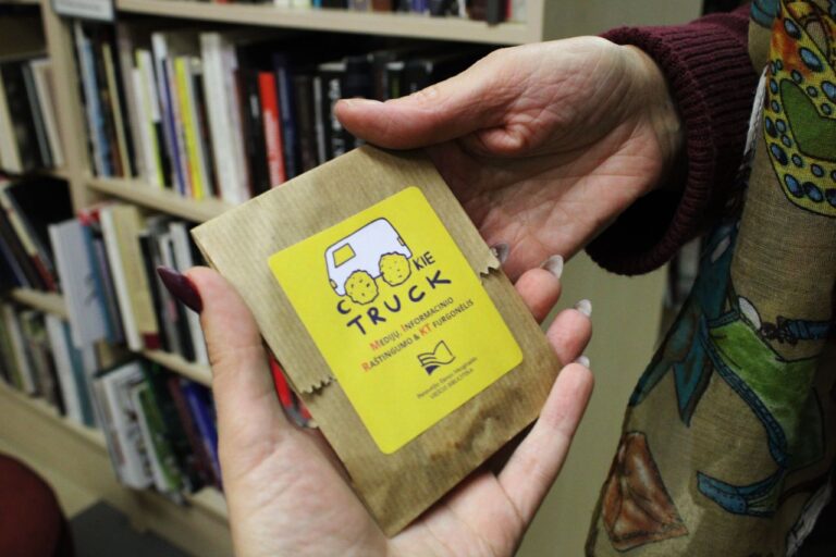 Rankose laikomas kvadratinis paketėlis su sausainių furgonėlio vizualika