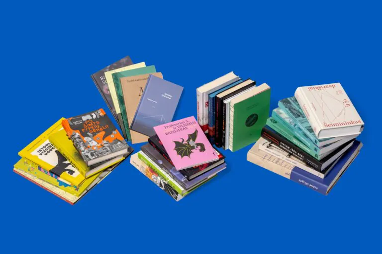 Suguldytos ir pastatytos akcijos nominantės knygos žydrame fone